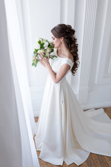Fototapeta premium elegant bride in traditional white dress sniffing wedding bouquet