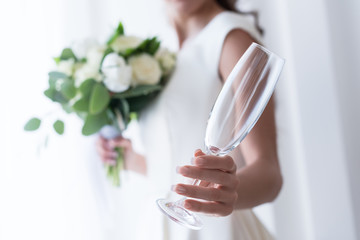 selective focus of bride with wedding bouquet holding empty champagne glass © LIGHTFIELD STUDIOS