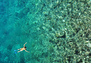Woman snorkeling in sea water. Aerial view