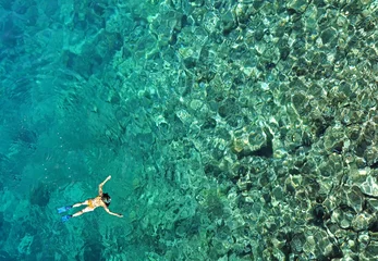 Rolgordijnen Woman snorkeling in sea water. Aerial view © salajean