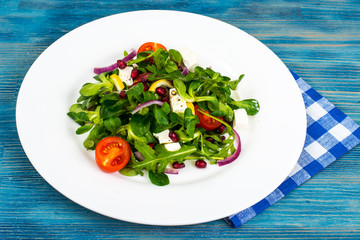Salad of fresh vegetables, goat cheese and pomegranate seeds