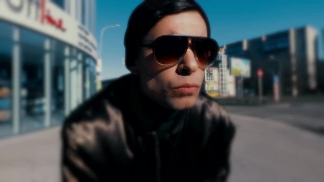 Portrait of a young guy in a slow-motion shooting on a city street