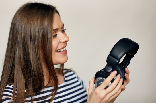 Close up portrait of Smiling woman holding earphones.