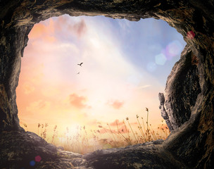 Resurrection of Easter Sunday concept: Tomb stone and meadow autumn sunrise background