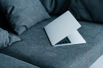 close up view of laptop on grey sofa