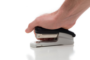 Stapler used by a male hand against a white background