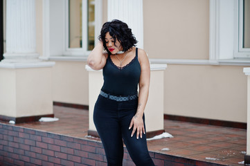 Fototapeta premium Stylish african american plus size model at streets of city on winter day.
