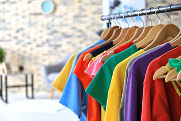 Rack with rainbow clothes indoors