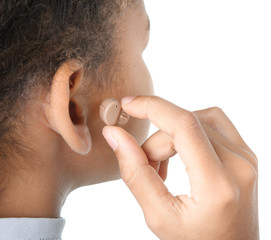 Fototapeta premium Little girl putting hearing aid in ear, closeup
