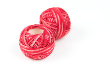 Two red sewing threads on a white background