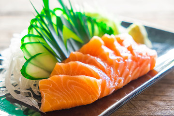 Sashimi, Salmon, Japanese food chopsticks and wasabi on the wood table
