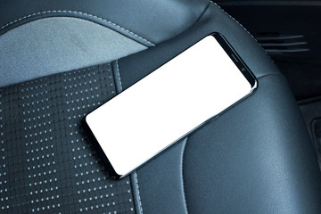 Mobile phone on car seat. Isolated screen for mockup. Black leather seat in background.