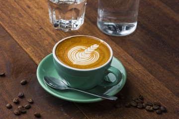 A Cup of hot latte art coffee on wooden table