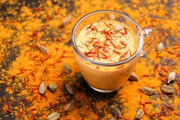 Indian turmeric milk with saffron, cardamom and turmeric. Copyspace