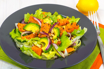 Delicious salad with avocado, pumpkin, greens