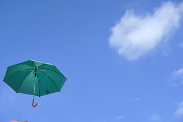 Fototapeta na wymiar umbrella flying on a blue sky