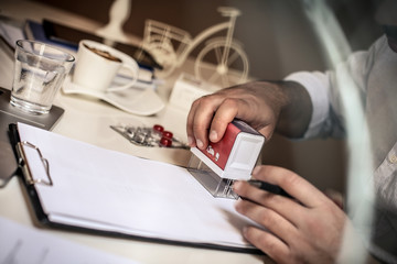 Business man using stamp for documents. Close up.