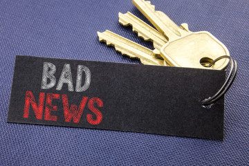 Handwritten text showing Bad News. Business concept writing for Failure Media Newspaper Written on note paper attached to the key, black background with space close up