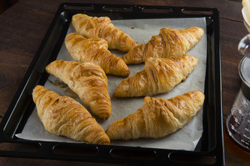 Fresh Croissants on rustic wooden background. Selective focus, horizontal.