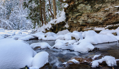 Waterfall in winter. Mountain river and snow on the mountain slopes