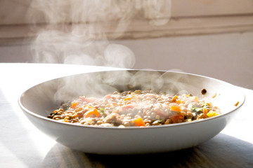 homemade dish of lentils with vegetables and carrots and smoke