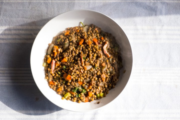 homemade dish of lentils with vegetables and carrots and smoke from above