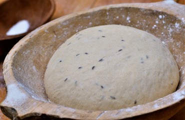 Rising bread dough in the wooden bowl
