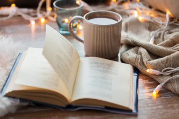 book and cup of coffee or hot chocolate on table