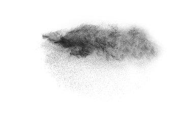 Black powder explosion against white background.The particles of charcoal splatted on white background. Closeup of black dust particles explode isolated on white background.