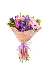 Naklejka premium Bouquet of pink gerberas, violet irises and pink, crimson tulips in a package of paper and satin, lilac ribbon. A holiday, a gift for a woman. Big and smart. Side view. Isolated.