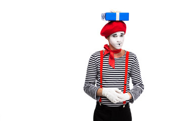 skeptical mime standing with gift box on head isolated on white