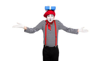 Fototapeta na wymiar mime showing shrug gesture with gift box on head isolated on white