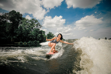 woman wakeboarding on wave down the river
