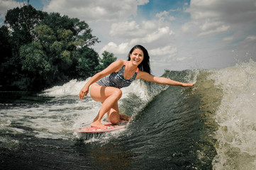 Female lifting up a lot of splashes by wakeboard