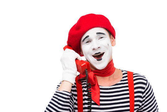 smiling mime talking by stationary telephone isolated on white