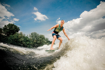 Fototapeta premium caucasian male riding stylish wakeboard on high wave