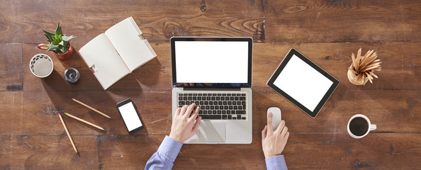 businessman is working at office checking informations via laptop. Notebook coffee and pencil are on the wood table