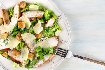 Chicken Caesar salad, closeup on light background with copyspace