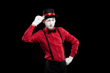 mime winking and greeting with hat isolated on black