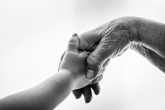 Kind und alte Frau halten die Hand