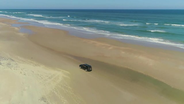camioneta manejando en la playa, toma a&eacute;rea