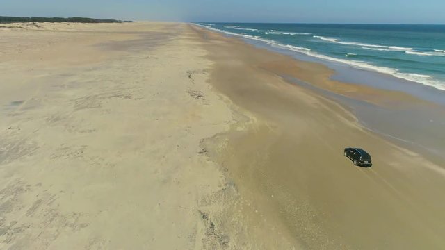camioneta manejando en la playa, toma a&eacute;rea
