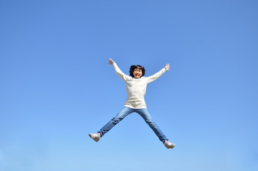 Fototapeta na wymiar 青空でジャンプする女の子