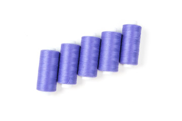 Five purple sewing threads on a white background, sewing and tailoring accessories and supplies