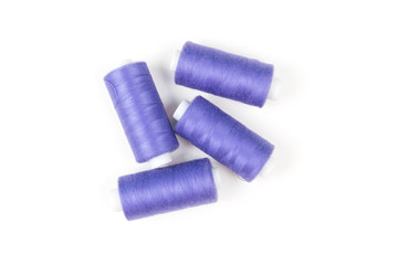 Four purple sewing threads on a white background