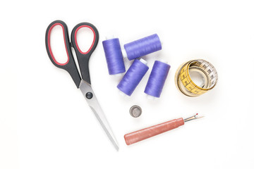 Sewing supplies and tools, medium purple sewing threads, yellow measuring tape with black numbers, big scissors, metal thimble and seam ripper on a white background