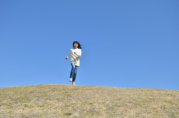 Fototapeta premium 青空で走る女の子