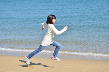 Fototapeta na wymiar ビーチで走る女の子