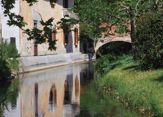 Fototapeta premium old house overlooking the canal with red brick arch bridge near Milan, Italy