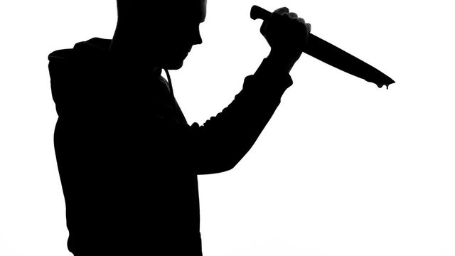 Aggressive killer holding sharp bloody knife, murder weapon, danger and horror